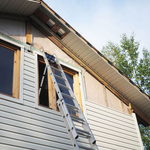 A New Home With Siding Being Installed.