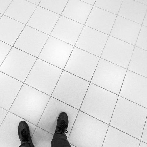 A Man Walks on Tile Office Flooring