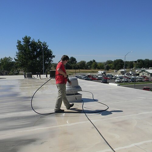 A Contractor Applies a Roof Restoration Coating.